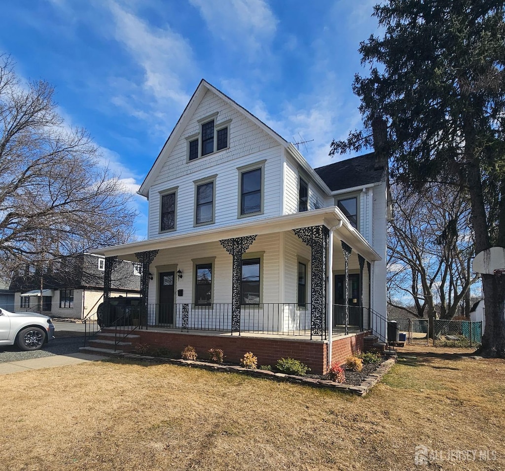 view of front of house featuring a front yard, covered porch, and cooling unit