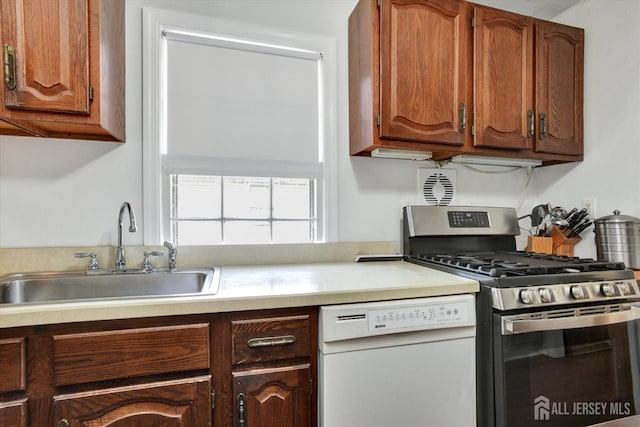 274 Prospect Ave, South Amboy, NJ 08879 - kitchen with stainless steel gas stove, white dishwasher, a sink, light countertops, and brown cabinetry