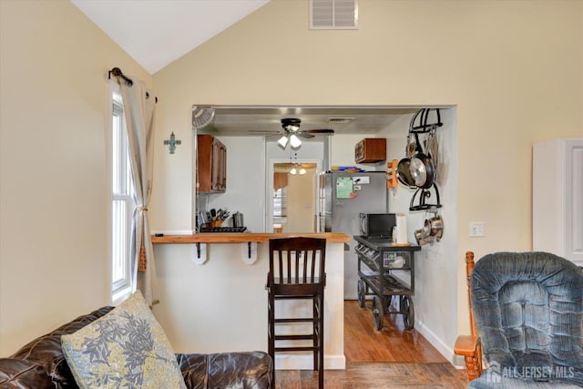 274 Prospect Ave, South Amboy, NJ 08879 - kitchen featuring a ceiling fan, wood finished floors, a kitchen bar, vaulted ceiling, and freestanding refrigerator