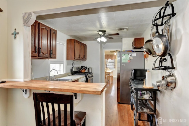 274 Prospect Ave, South Amboy, NJ 08879 - kitchen featuring stainless steel appliances, a sink, wooden counters, a kitchen breakfast bar, and a ceiling fan