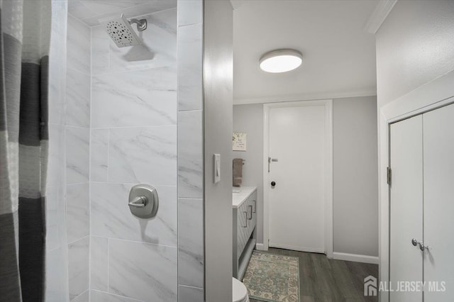 44 Lakeside Dr S, Piscataway, NJ 08854 - bathroom featuring wood finished floors, a tile shower, vanity, ornamental molding, and baseboards
