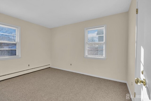 empty room featuring carpet and a baseboard radiator