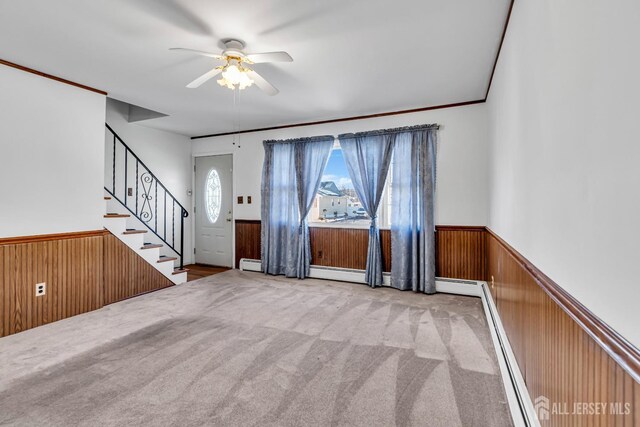 interior space with ceiling fan, light colored carpet, and a baseboard radiator