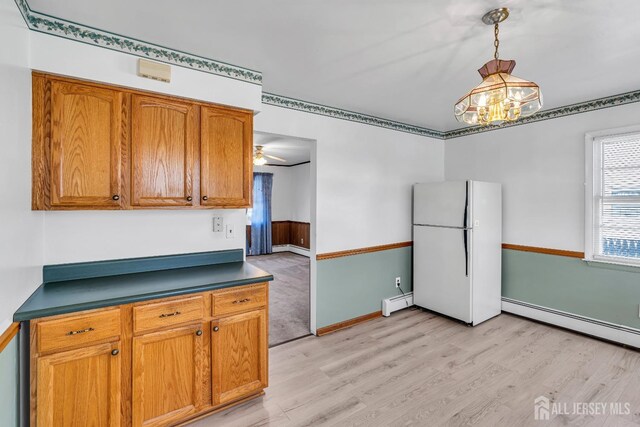 kitchen featuring baseboard heating, decorative light fixtures, white fridge, light hardwood / wood-style floors, and ceiling fan