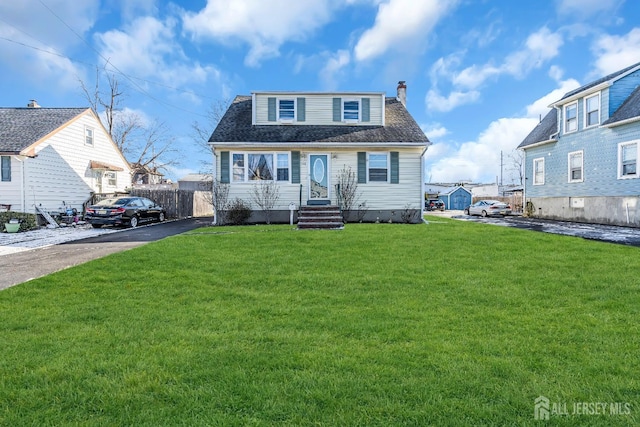 view of front of house with a front lawn, roof with shingles, a chimney, and fence