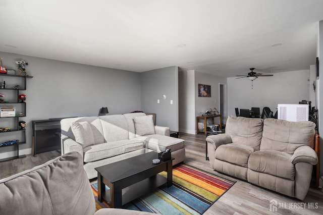 living area featuring ceiling fan, baseboards, and wood finished floors