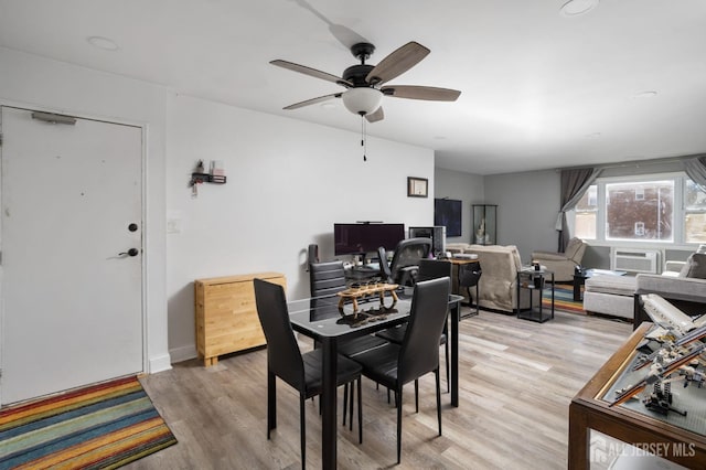 dining area with light wood-type flooring, a ceiling fan, and baseboards