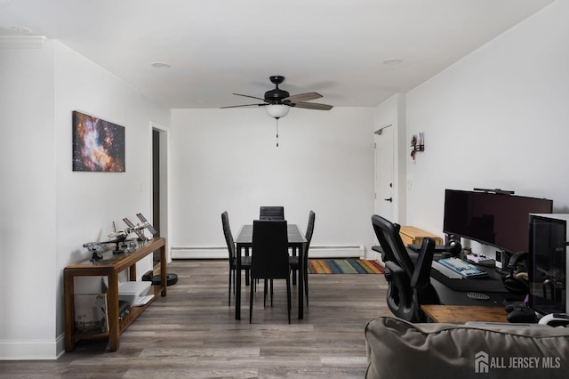 dining room with ceiling fan, baseboard heating, and wood finished floors