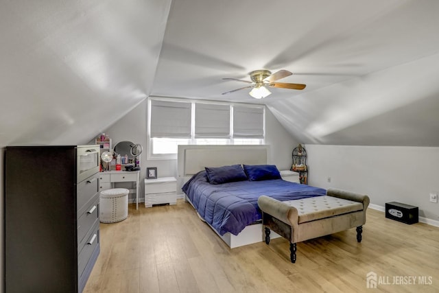 bedroom with light wood-style flooring, a ceiling fan, lofted ceiling, and baseboards