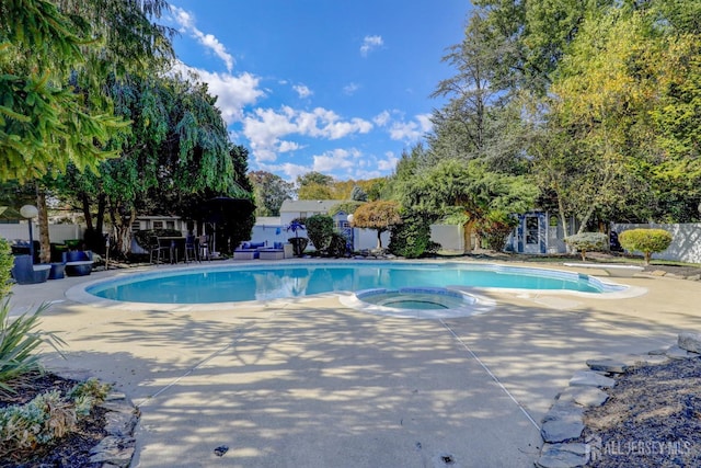 outdoor pool featuring an in ground hot tub, fence, a diving board, and a patio area