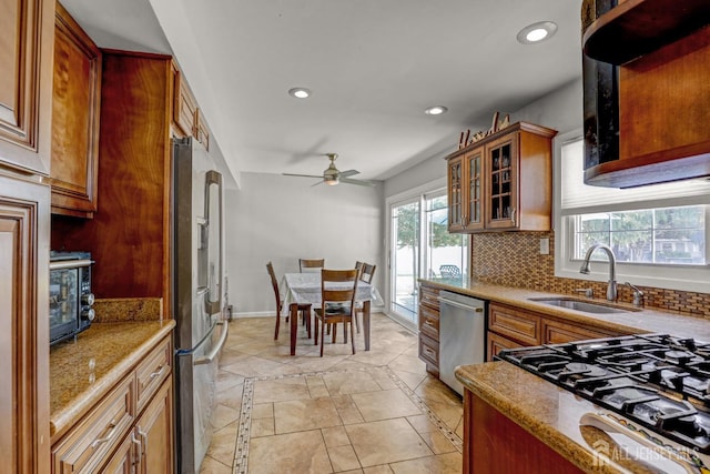 kitchen featuring a ceiling fan, a sink, tasteful backsplash, recessed lighting, and appliances with stainless steel finishes