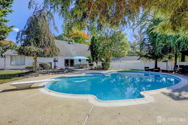 view of swimming pool with an in ground hot tub, a fenced in pool, a patio area, and fence