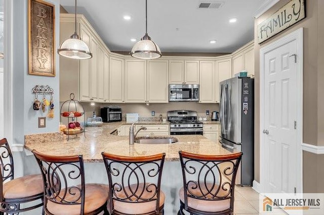 7203 Minuteman Ln, Franklin, NJ 08873 - kitchen featuring stainless steel appliances, a peninsula, a breakfast bar area, light stone counters, and decorative light fixtures