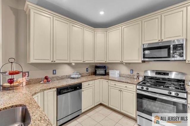 7203 Minuteman Ln, Franklin, NJ 08873 - kitchen featuring stainless steel appliances, cream cabinets, light stone countertops, and light tile patterned floors