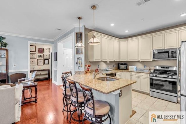 7203 Minuteman Ln, Franklin, NJ 08873 - kitchen featuring stainless steel appliances, a peninsula, a breakfast bar, recessed lighting, and hanging light fixtures