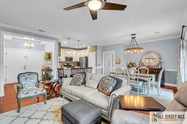 7203 Minuteman Ln, Franklin, NJ 08873 - living area featuring a ceiling fan, a chandelier, wood finished floors, and ornamental molding