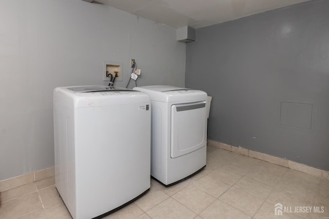 washroom featuring laundry area, baseboards, light tile patterned flooring, and independent washer and dryer