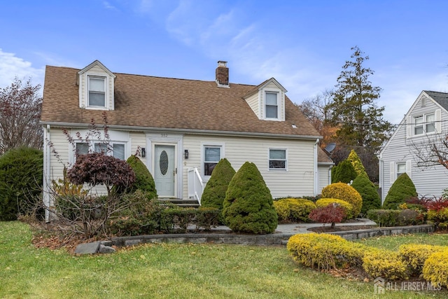 cape cod-style house featuring a front lawn, roof with shingles, and a chimney