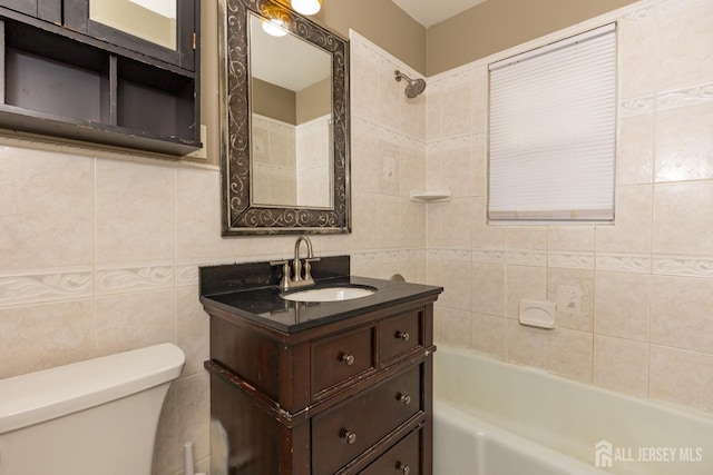 bathroom with shower / washtub combination, vanity, toilet, and tile walls