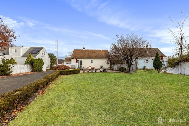 view of front of house featuring fence and a front yard