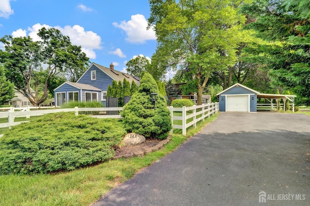 10 Shaw Dr, Franklin, NJ 08528 - view of front facade with driveway, a chimney, and a detached garage