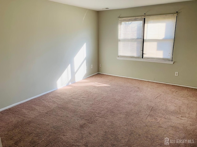 carpeted spare room featuring visible vents and baseboards