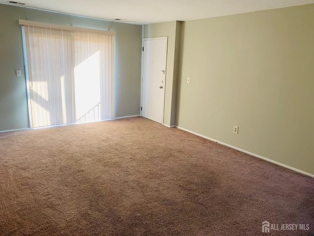 carpeted spare room with visible vents and baseboards