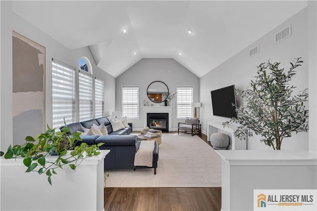11 Hawk Ct, East Brunswick, NJ 08816 - living room with dark wood finished floors, a glass covered fireplace, vaulted ceiling, and recessed lighting