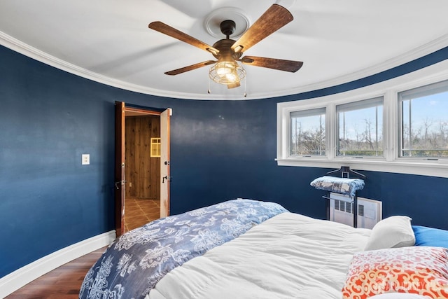 bedroom with a ceiling fan, baseboards, radiator, and crown molding