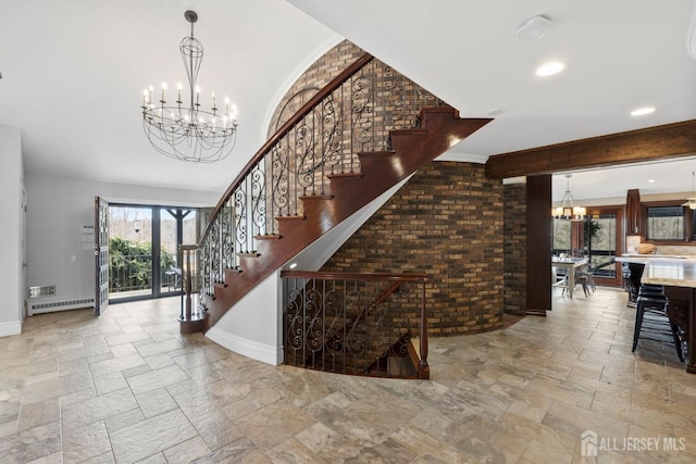 staircase with brick wall, baseboards, a chandelier, stone tile floors, and a baseboard radiator