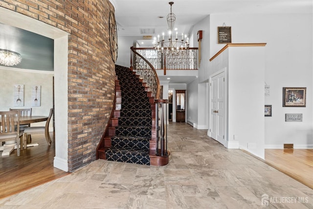 13 Eagle Nest Rd, Colts Neck, NJ 07722 - entryway featuring a towering ceiling, a chandelier, baseboards, stone finish flooring, and stairs
