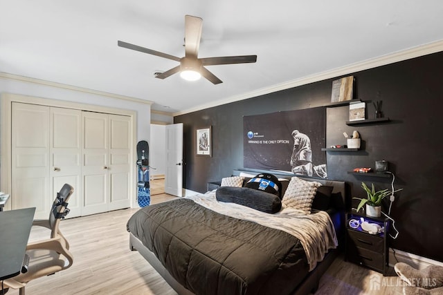 bedroom with crown molding, wood finished floors, a closet, and ceiling fan