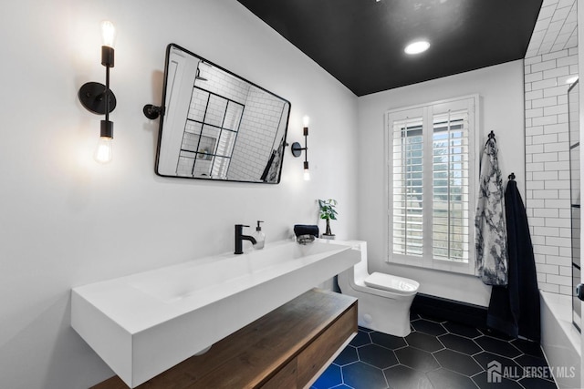 bathroom featuring toilet, shower / washtub combination, vanity, and tile patterned flooring