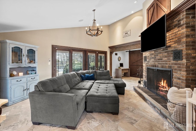 living room featuring high vaulted ceiling, a notable chandelier, recessed lighting, a barn door, and a brick fireplace