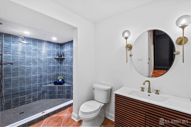 bathroom featuring vanity, baseboards, a tile shower, tile patterned flooring, and toilet