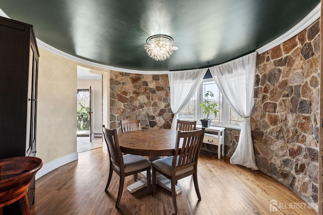 dining space featuring a notable chandelier, crown molding, baseboards, and wood finished floors