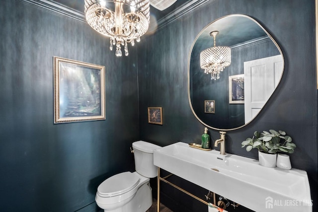 bathroom featuring a notable chandelier, toilet, and crown molding