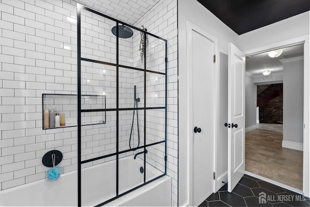 full bath featuring tile patterned floors, baseboards, shower / bath combination with glass door, and crown molding