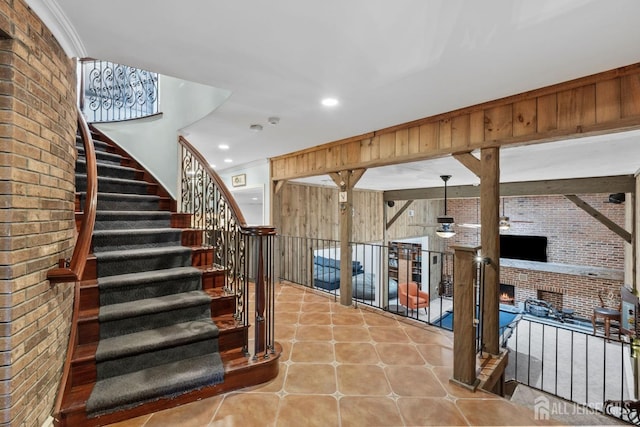 13 Eagle Nest Rd, Colts Neck, NJ 07722 - stairs with brick wall, a warm lit fireplace, tile patterned floors, and recessed lighting