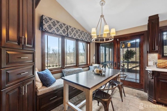 dining room featuring an inviting chandelier and vaulted ceiling