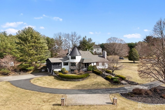 view of front of house with aphalt driveway and a front lawn