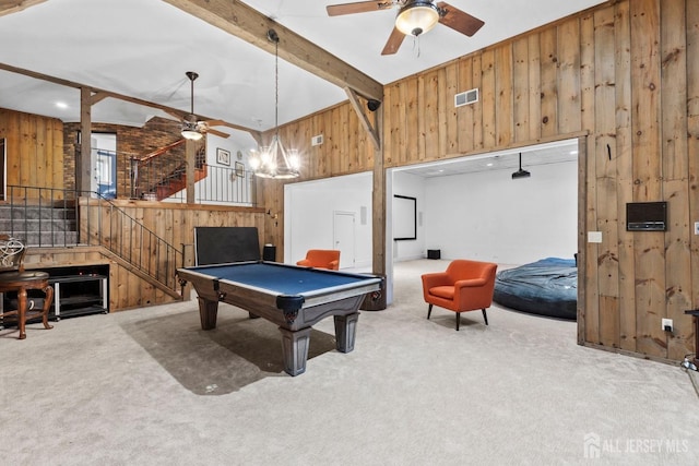 rec room with beam ceiling, visible vents, wood walls, and carpet