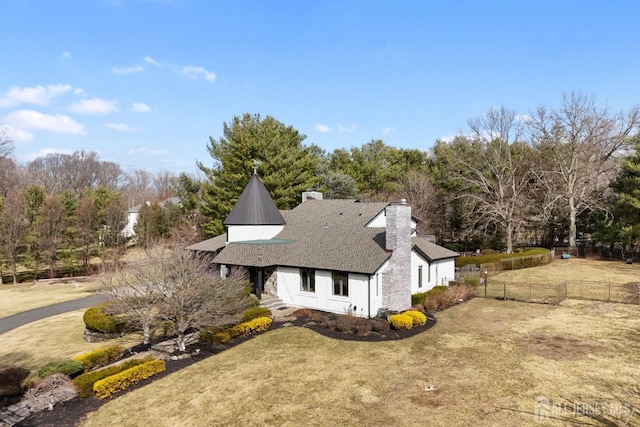 view of property exterior with a lawn, a chimney, roof with shingles, and fence