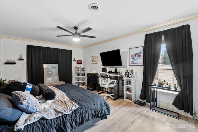 bedroom featuring crown molding, visible vents, light wood finished floors, and ceiling fan