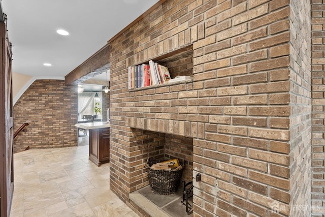 bathroom with recessed lighting, brick wall, and stone finish floor