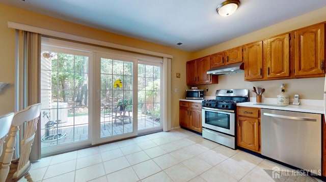 1406 Locust Ct, South Brunswick, NJ 08852 - kitchen featuring stainless steel appliances, under cabinet range hood, light countertops, brown cabinets, and light tile patterned floors