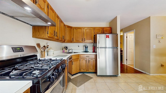 1406 Locust Ct, South Brunswick, NJ 08852 - kitchen featuring stainless steel appliances, under cabinet range hood, light countertops, brown cabinets, and light tile patterned floors
