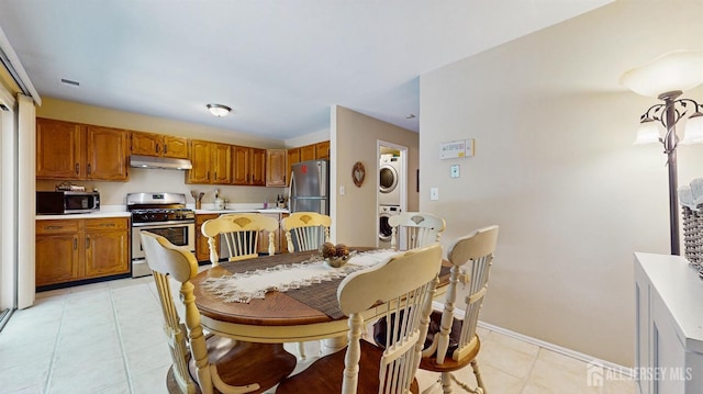 1406 Locust Ct, South Brunswick, NJ 08852 - kitchen with stainless steel appliances, estacked washer and dryer, under cabinet range hood, light countertops, and brown cabinets