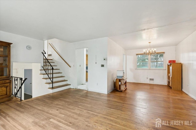 796 Curie Rd, North Brunswick, NJ 08902 - unfurnished living room featuring wood finished floors, a chandelier, and stairway