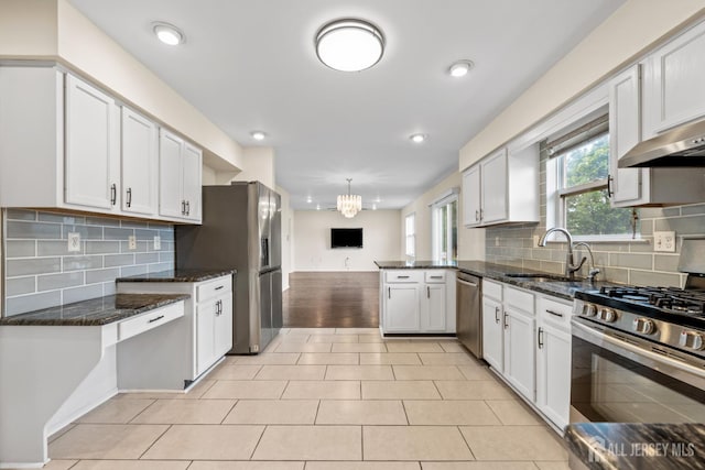 96 Lark Dr, South River, NJ 08882 - kitchen featuring stainless steel appliances, a peninsula, a chandelier, tasteful backsplash, and recessed lighting